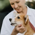 kobieta trzymającego w rękach psa corgi
